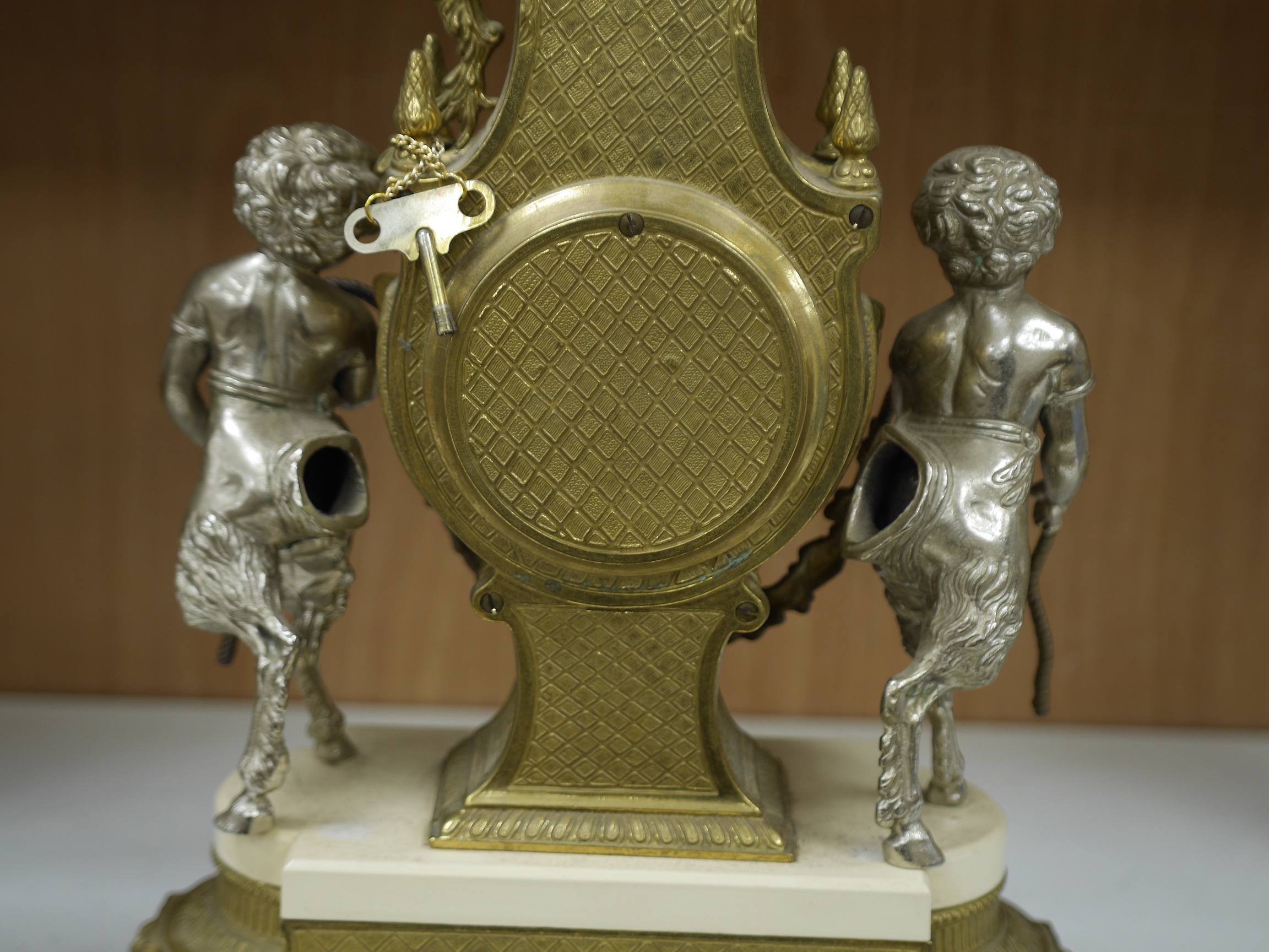 An ornate mixed metal putti clock and five light garniture, garnitures 59.5cm high. Condition - fair to good